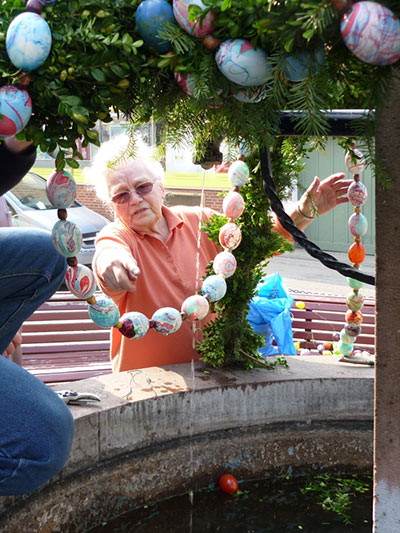 Ruth Steiger beim Schmücken des Osterbrunnens