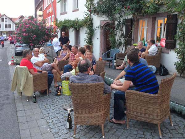 Menschen, die an der Straße draußen sitzen und sich unterhalten